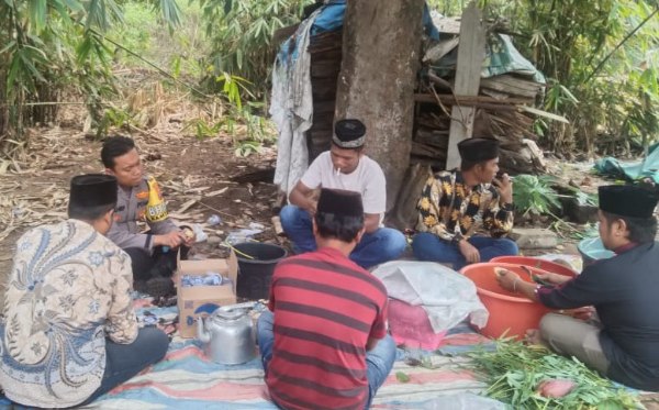 Bhabinkamtibmas polsek Barumun Tengah saat menghadiri giat menghabisi hari sambil membantu di rumah duka warga yang meninggal. (And/ist)